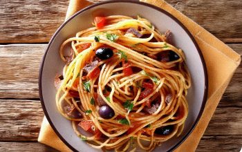 A plate of Spaghetti Puttanesca with olives, capers, and a rustic setting