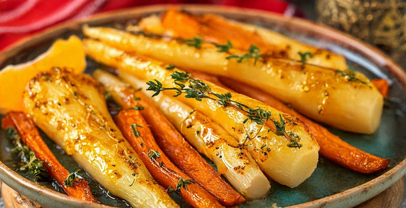 Roasted parsnips glazed with honey and citrus zest, garnished with fresh thyme, served on a rustic plate.