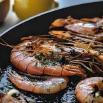 Shrimp sizzling in a pan with garlic and herbs.