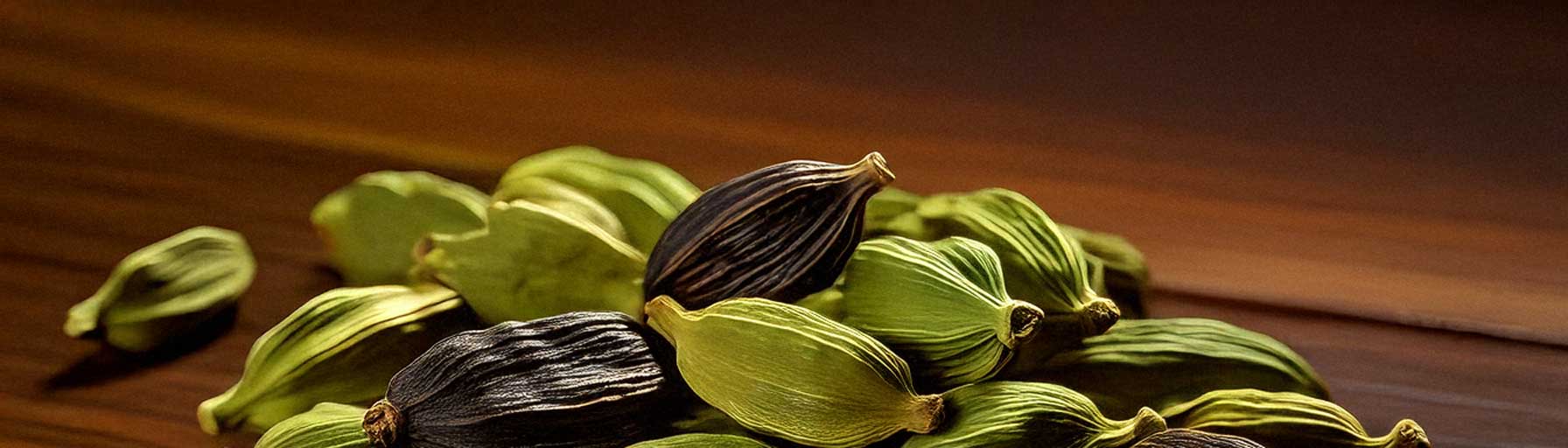 A studio-quality arrangement of green and black cardamom pods with seeds displayed on a white background, highlighting their culinary appeal.